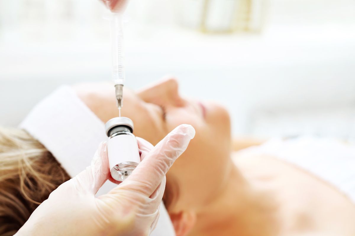 Cosmetic physician prepares a syringe for mesotherapy skin treatment