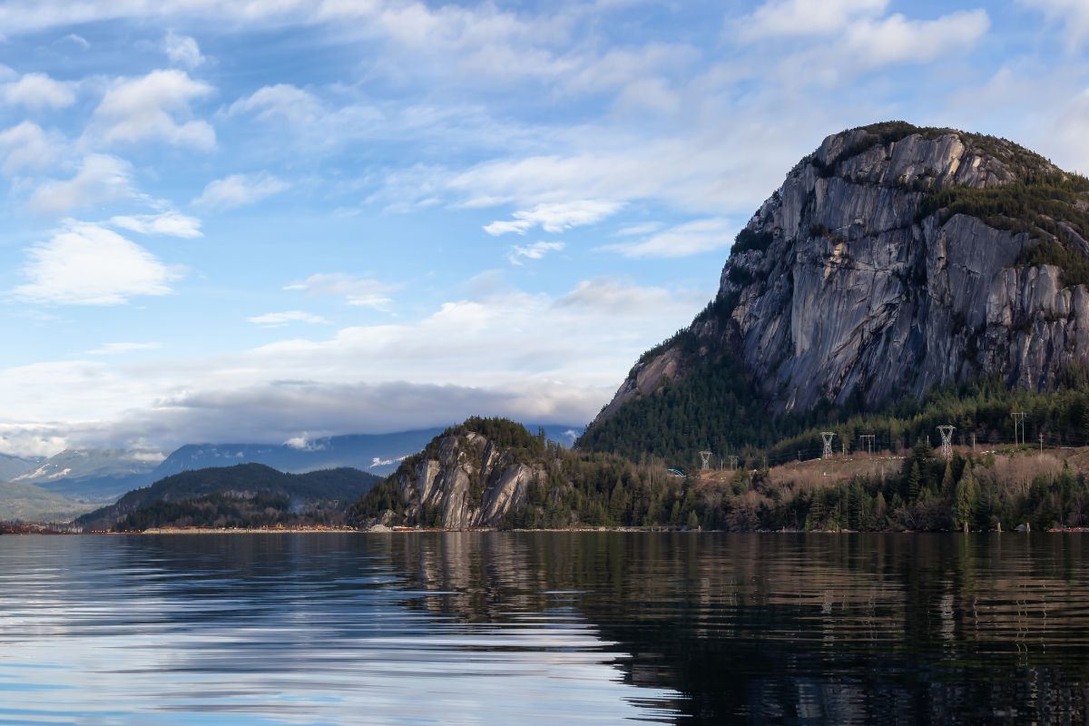 View of the Squamish Chief granite mountain face on a clear day, with Howe Sound in the foreground.